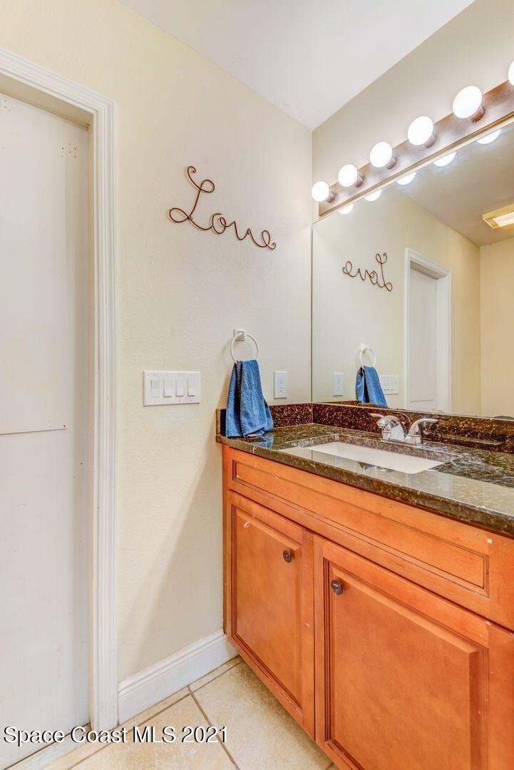 6025 Adina Road Cocoa, FL 32927 - Photo 21 of 22 a bathroom with a sink and mirror