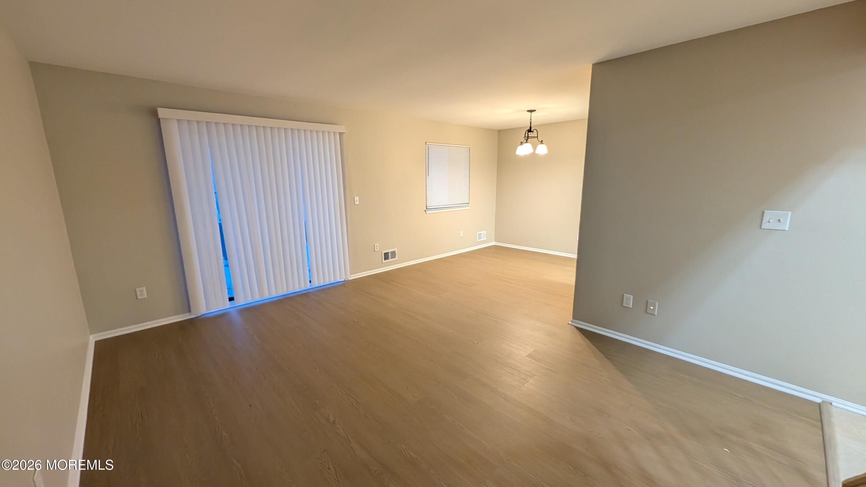 21 Jesse Road Howell, NJ 07731 - Photo 2 of 30 an empty room with wooden floor and windows