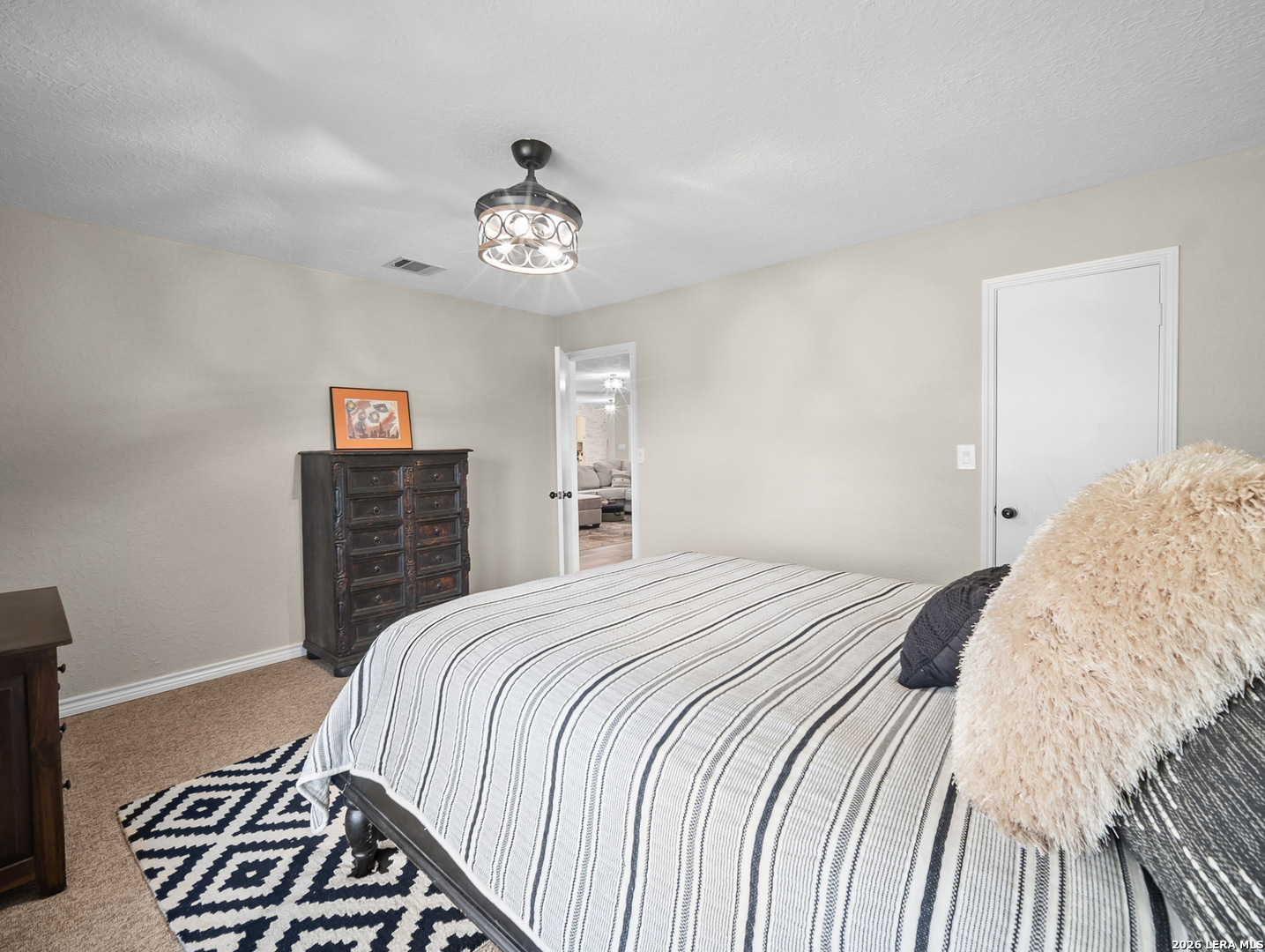 3620 Chestnut Court Cibolo, TX 78108 - Photo 31 of 45 a bedroom with a bed and a chandelier