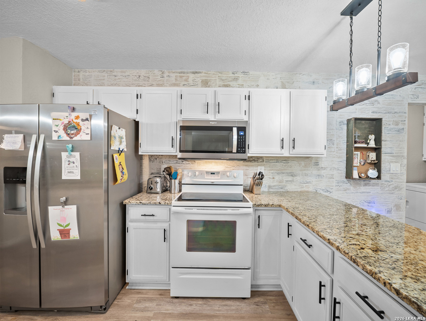 3620 Chestnut Court Cibolo, TX 78108 - Photo 10 of 45 a kitchen with granite countertop a white stove top oven and cabinets