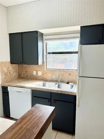 a kitchen with a sink a refrigerator and a stove