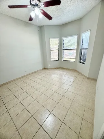 an empty room with windows and fan