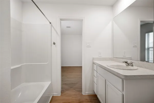 a bathroom with a bathtub a sink a vanity and a shower