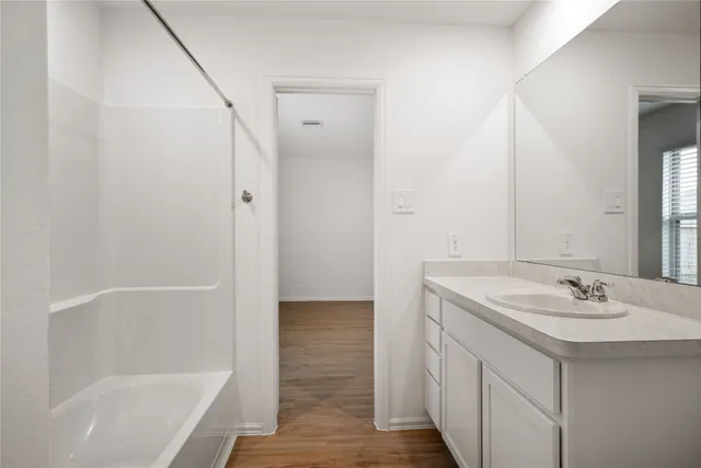 a bathroom with a bathtub a sink a vanity and a shower