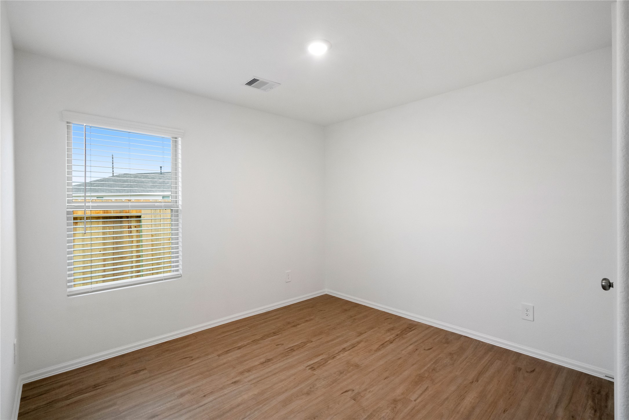 104 Pine Bend Magnolia, TX 77354 - Photo 17 of 25 a view of an empty room with wooden floor and a window