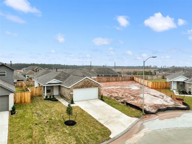 an aerial view of ocean and residential houses with outdoor space