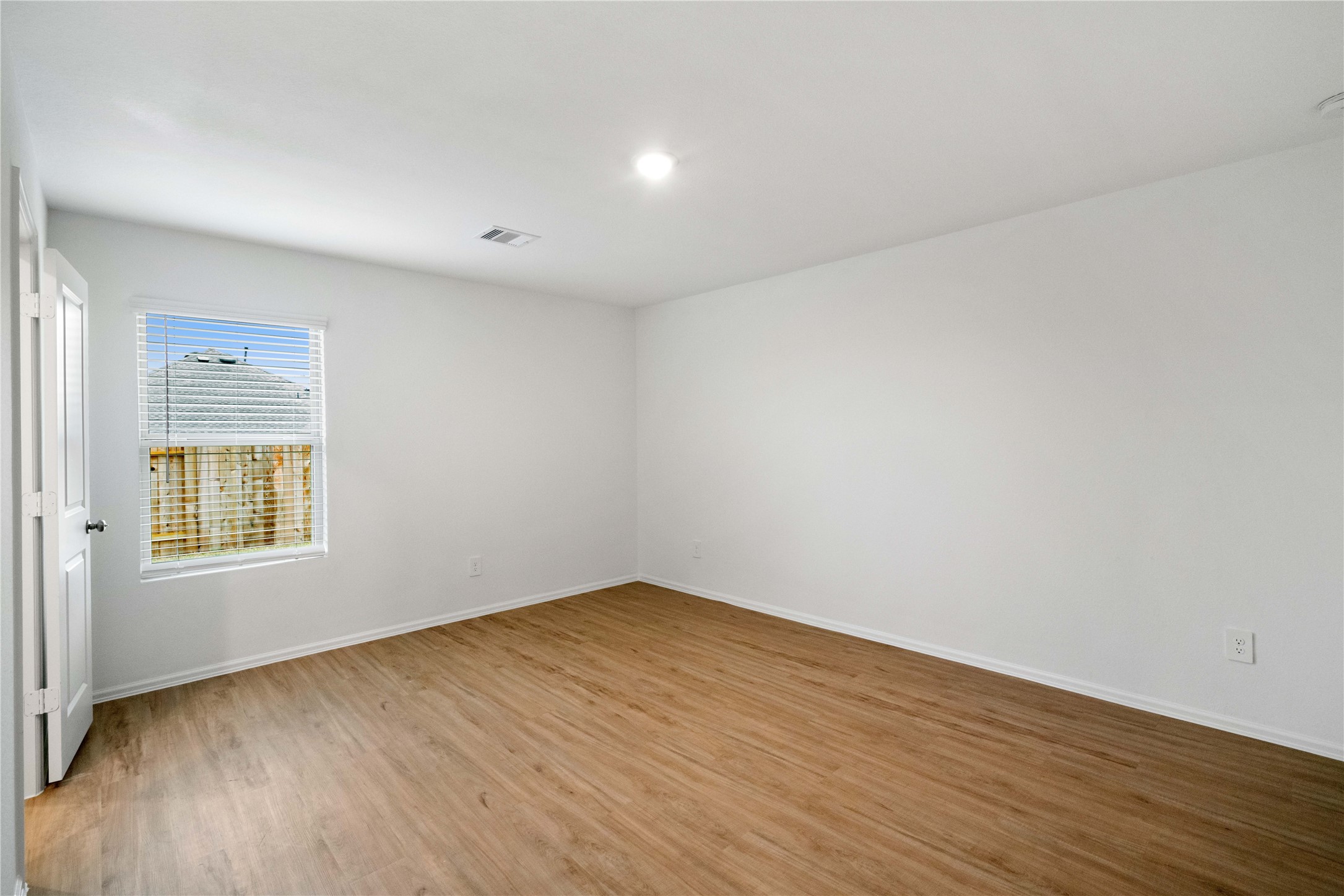 104 Pine Bend Magnolia, TX 77354 - Photo 10 of 25 a view of an empty room with wooden floor and a window