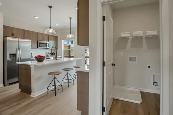 a kitchen with kitchen island a refrigerator stove and sink