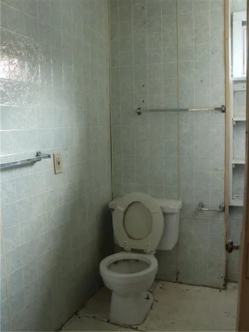 a bathroom with a granite countertop toilet a sink and a shower