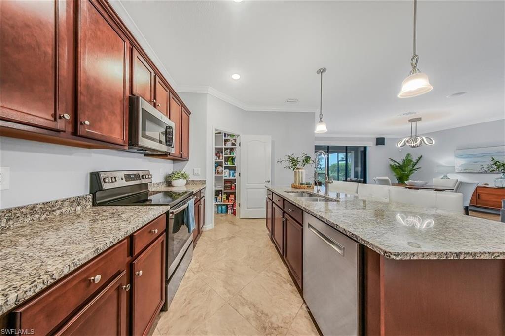 19862 Bittersweet Lane Estero, FL 33928 - Photo 12 of 50 a kitchen with stainless steel appliances granite countertop a sink a stove and a wooden floors