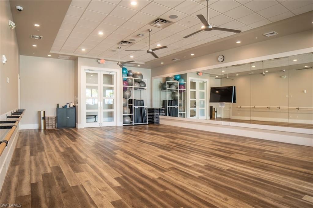19862 Bittersweet Lane Estero, FL 33928 - Photo 44 of 50 Exercise area featuring ceiling fan, a paneled ceiling, wood finished floors, french doors, and recessed lighting