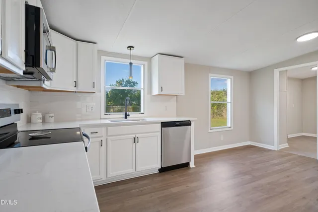 a kitchen with stainless steel appliances granite countertop a sink a stove a refrigerator and cabinets