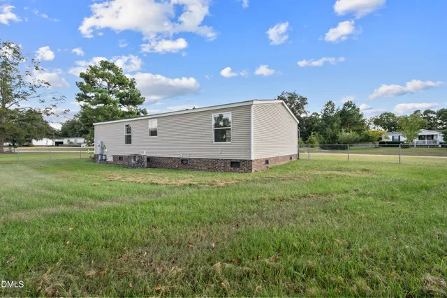 a view of a backyard with grass and a large tree