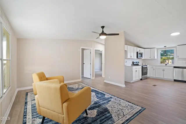 a living room with furniture and kitchen view