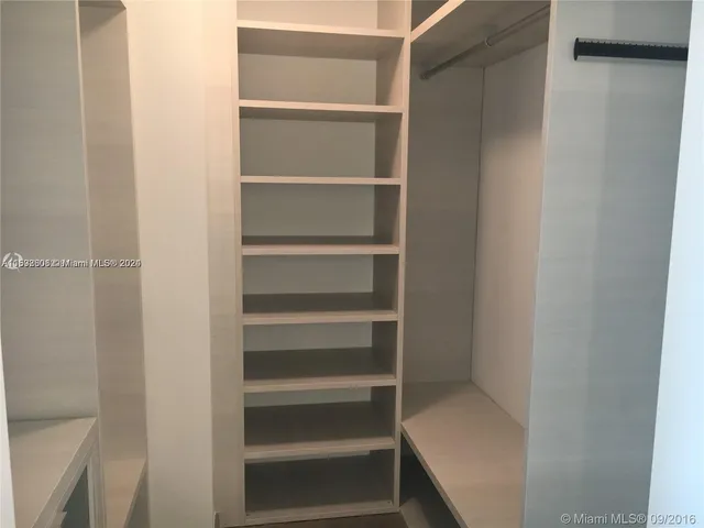 a view of walk in closet with empty racks