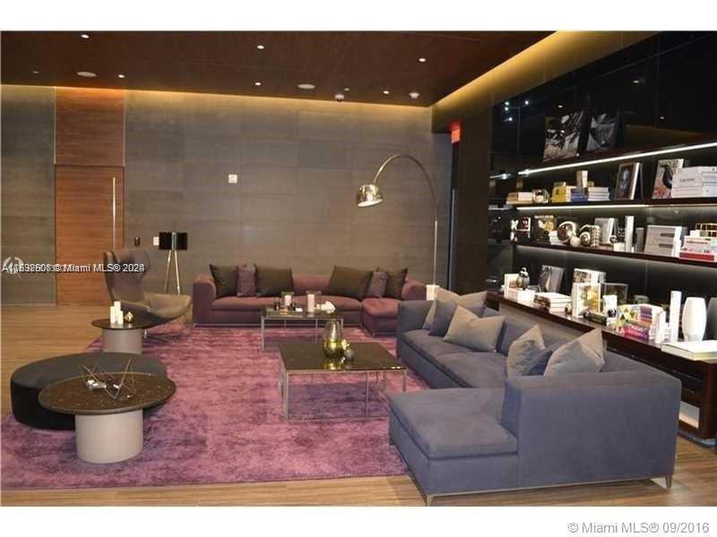 68 Southeast 6th Street, Unit 3510 Miami, FL 33131 - Photo 13 of 20 a living room with furniture a rug and a book shelf