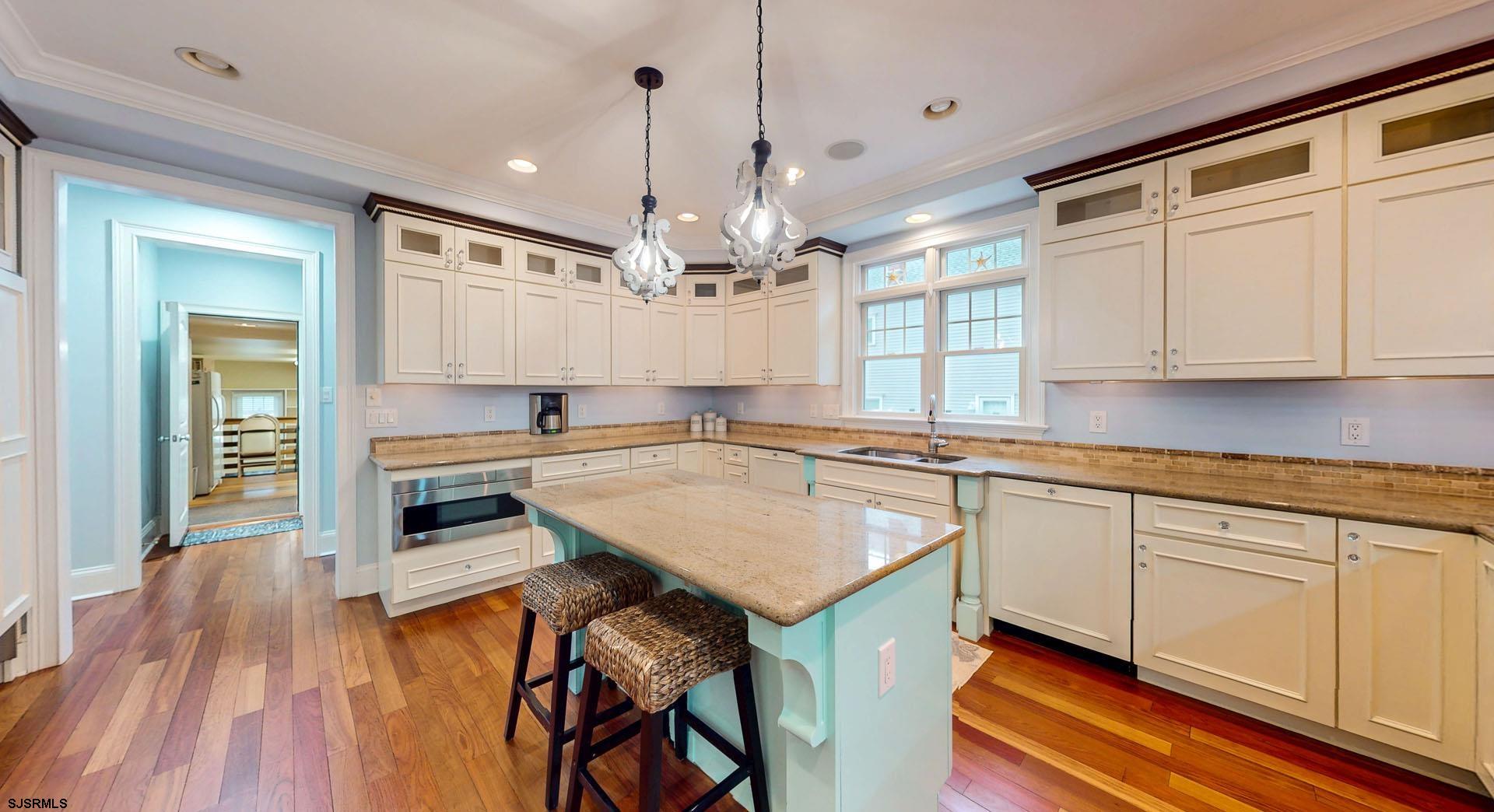 53 Bay Road Ocean City, NJ 08226 - Photo 17 of 68 a kitchen with kitchen island granite countertop a sink cabinets and wooden floor