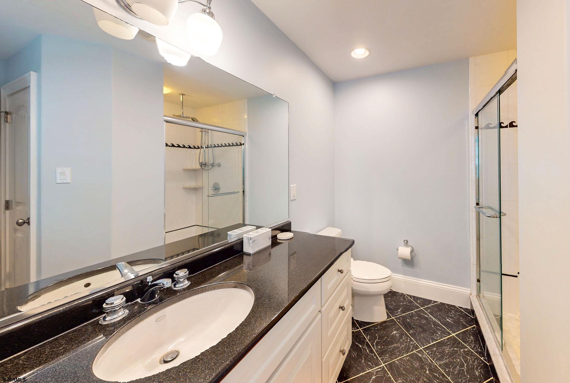 53 Bay Road Ocean City, NJ 08226 - Photo 30 of 68 a bathroom with a granite countertop sink toilet a mirror and shower
