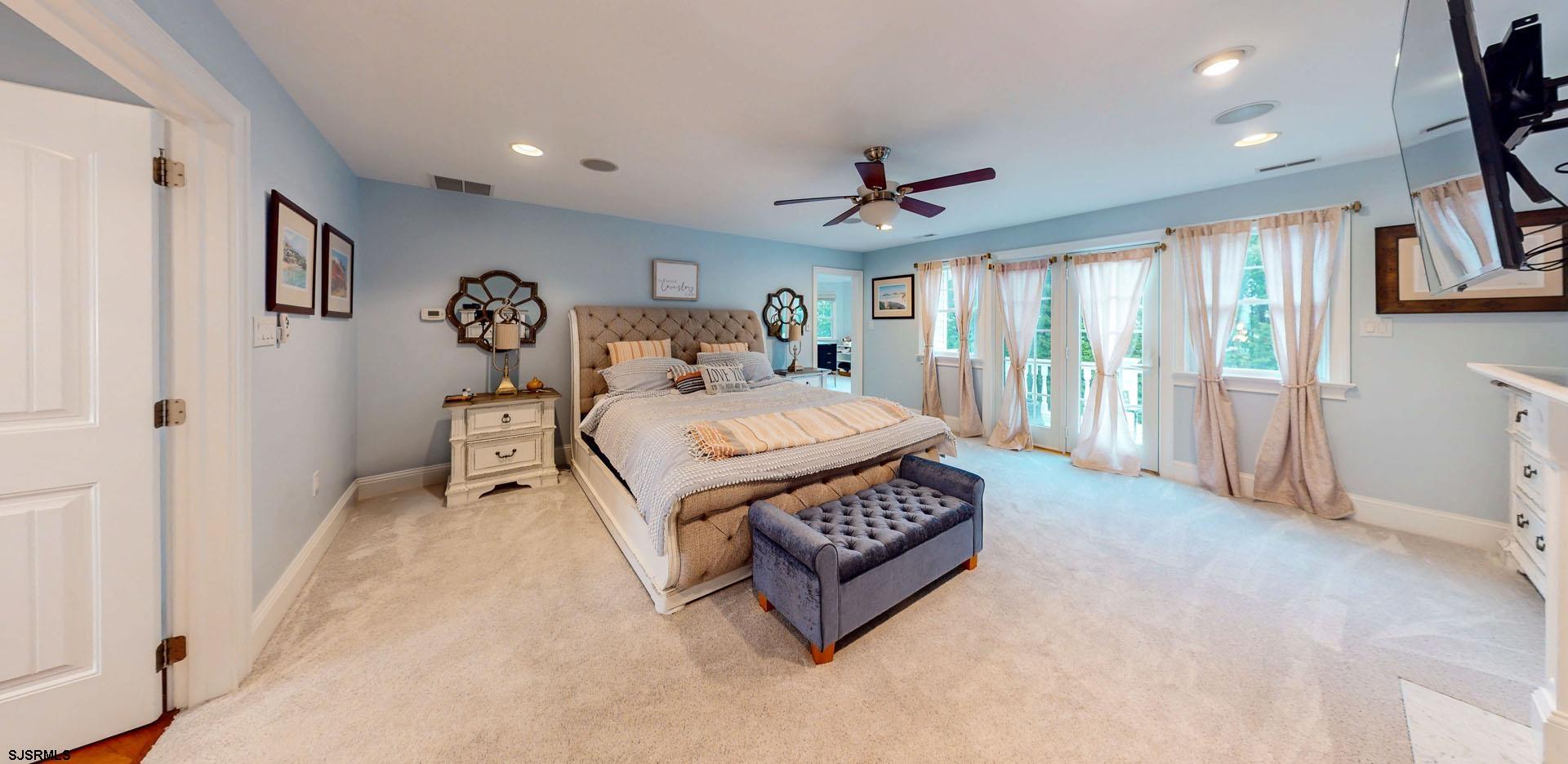 53 Bay Road Ocean City, NJ 08226 - Photo 36 of 68 a spacious bedroom with a bed a flat screen tv and a large window