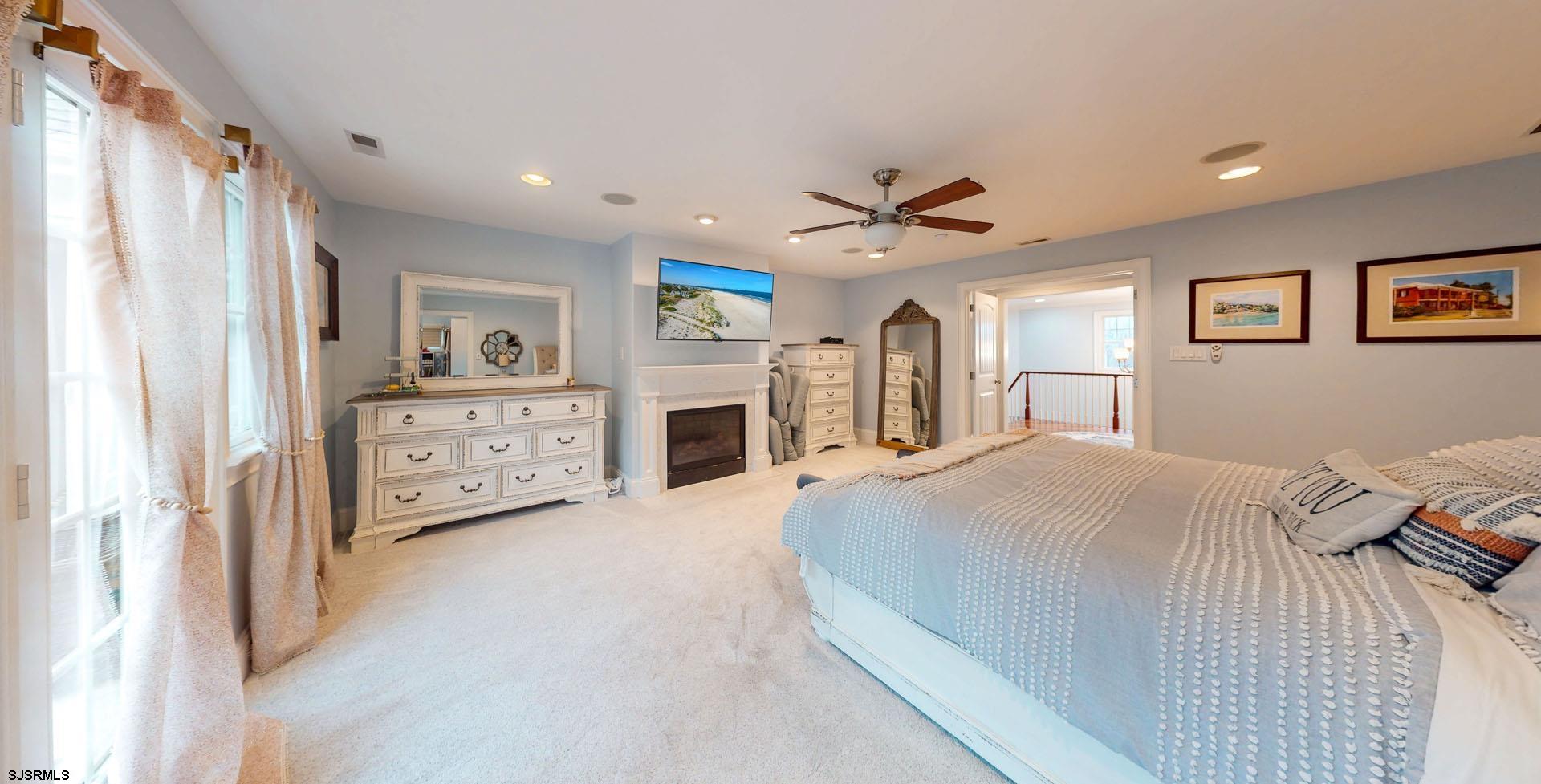 53 Bay Road Ocean City, NJ 08226 - Photo 38 of 68 a spacious bedroom with a large bed and a chandelier