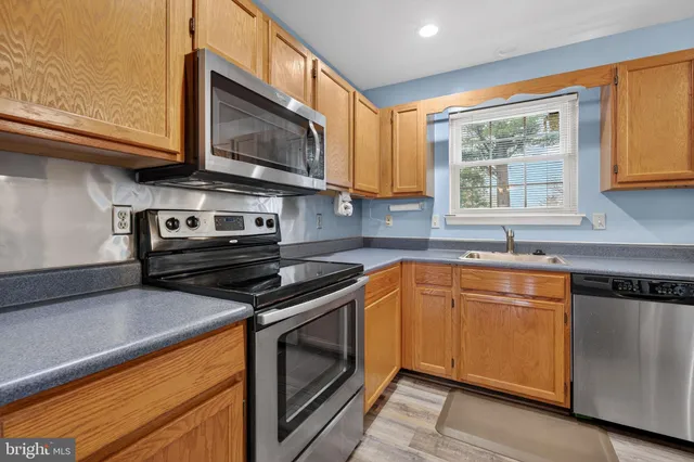a kitchen with stainless steel appliances granite countertop a stove a sink and a microwave