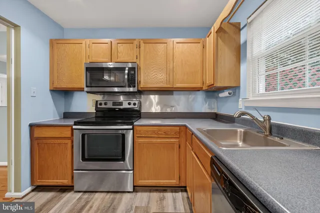 a kitchen with a sink a stove and microwave