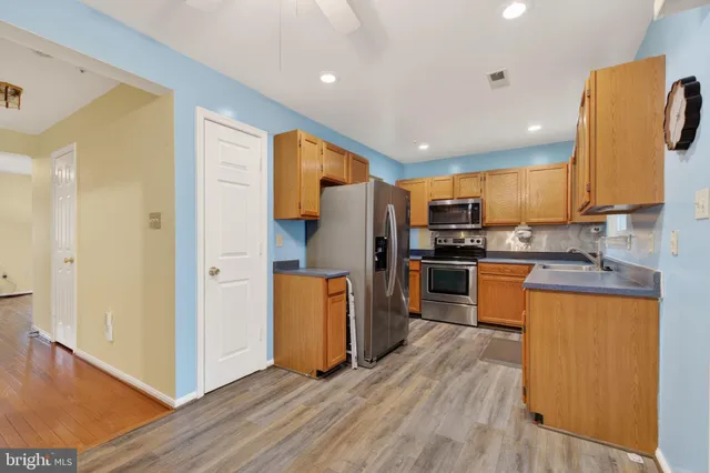 a kitchen with stainless steel appliances a refrigerator and a stove top oven