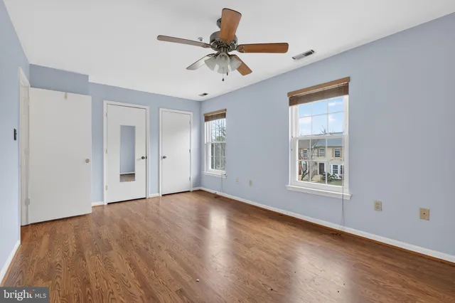 a view of room with window ceiling fan and hardwood floor