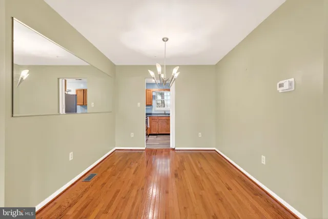 a view of a room with wooden floor and chandelier