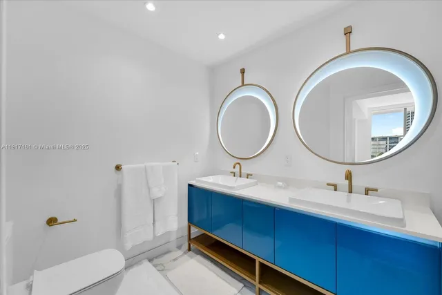 a bathroom with a toilet mirror vanity and a sink