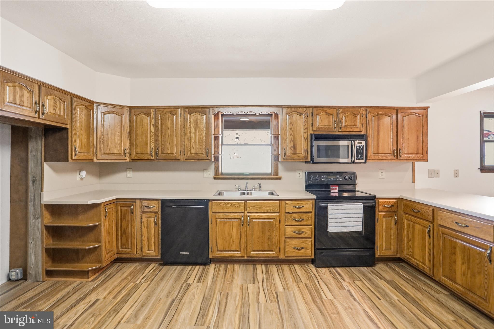 12623 Windy Ridge Drive Mount Savage, MD 21545 - Photo 25 of 72 a kitchen with stainless steel appliances granite countertop a stove a sink dishwasher and a microwave oven with wooden floor