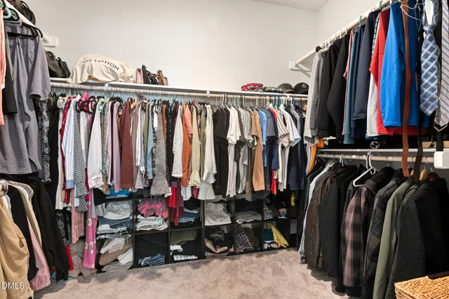 a view of walk in closet with clothes