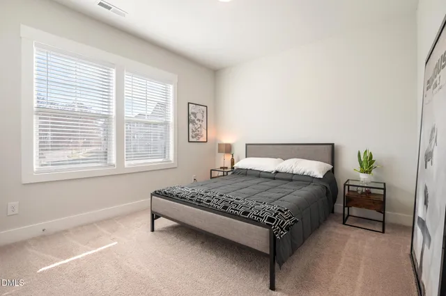 a bedroom with a bed lamp and a window