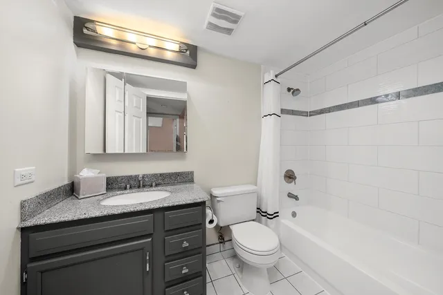 a bathroom with a granite countertop sink toilet a mirror and bathtub