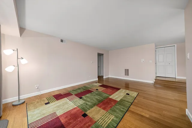 a view of an empty room and wooden floor
