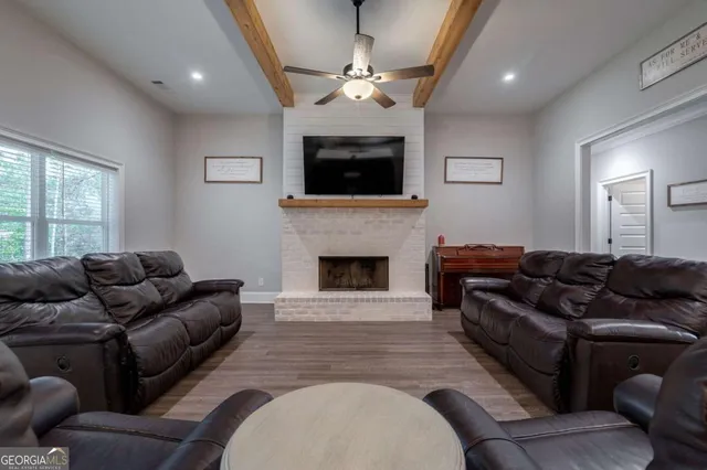 a living room with furniture a flat screen tv and a fireplace