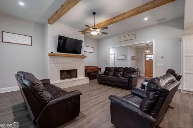 a living room with furniture a flat screen tv and a fireplace