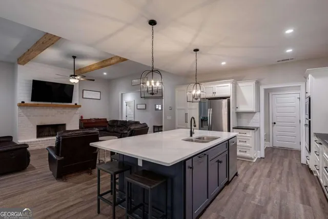 a kitchen with stainless steel appliances a dining table chairs and white cabinets