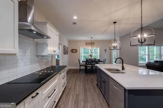 a kitchen with a dining table chairs stainless steel appliances and cabinets