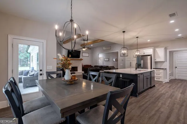 a dining room with furniture a chandelier and wooden floor
