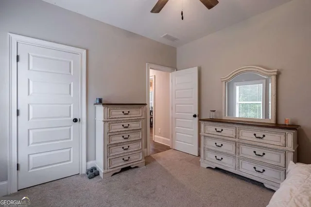 a bedroom with a bed a window and a flat screen television