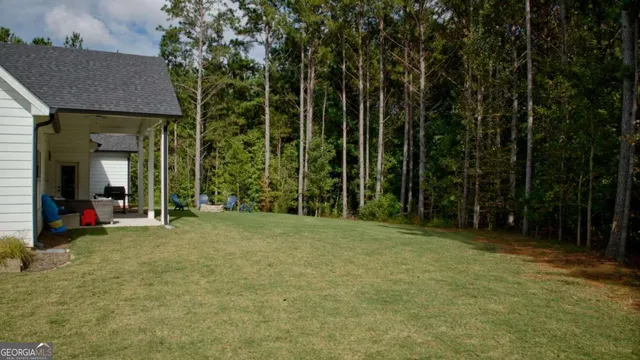 a view of a house with backyard and sitting area