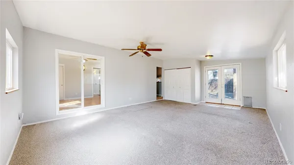an empty room with fan and windows