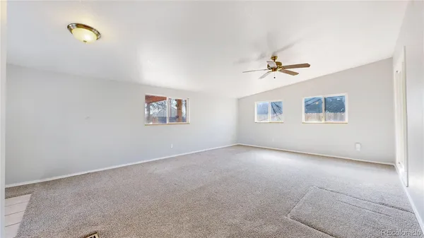 an empty room with a window and a ceiling fan
