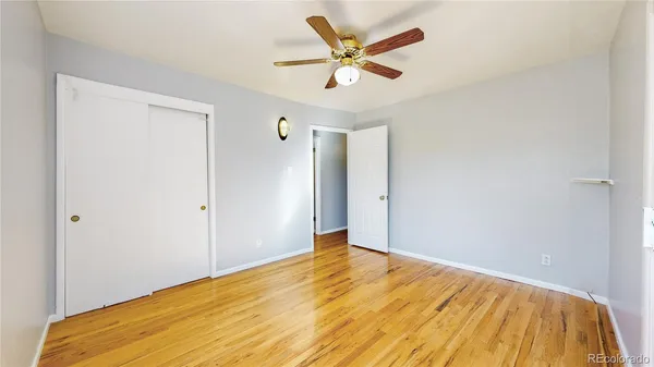 a view of a big room with wooden floor and a ceiling fan