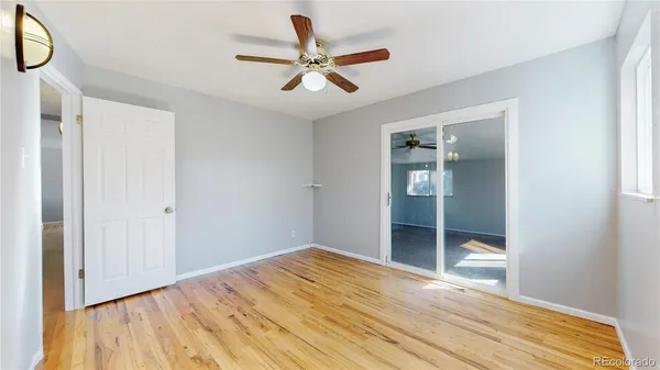 a view of a livingroom with wooden floor and a ceiling fan
