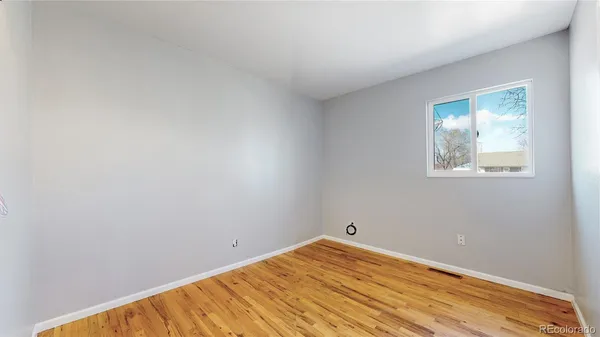 a view of empty room with wooden floor