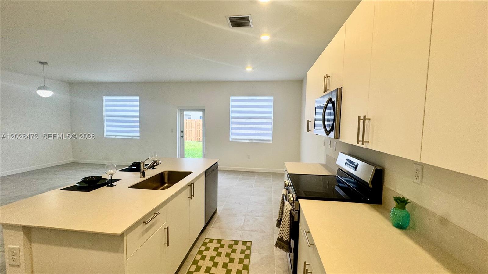 19479 Southwest 340th Street, Unit 1 Homestead, FL 33034 - Photo 36 of 58 a kitchen with a sink a stove and a refrigerator