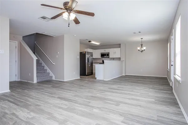 a view of empty room with wooden floor and ceiling fan
