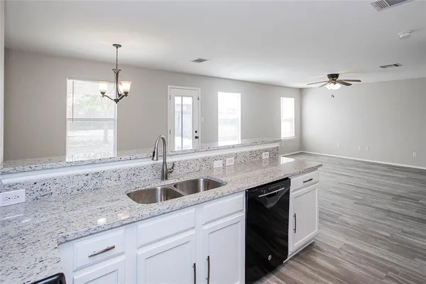 a kitchen with granite countertop a sink and cabinets
